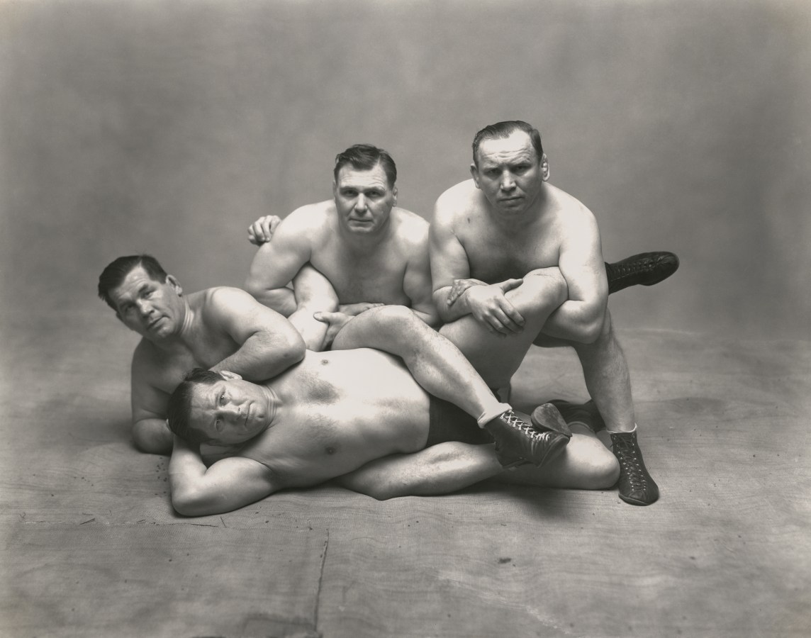 Black and white photograph of four wrestling brothers in a pose on the floor