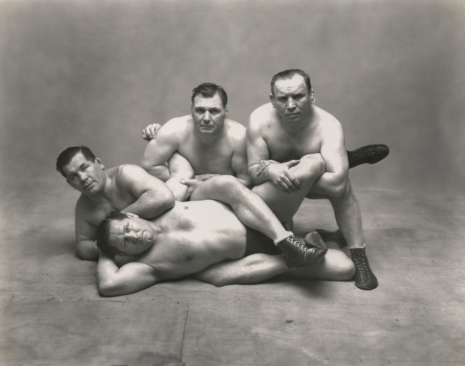 Black and white photograph of four wrestling brothers in a pose on the floor