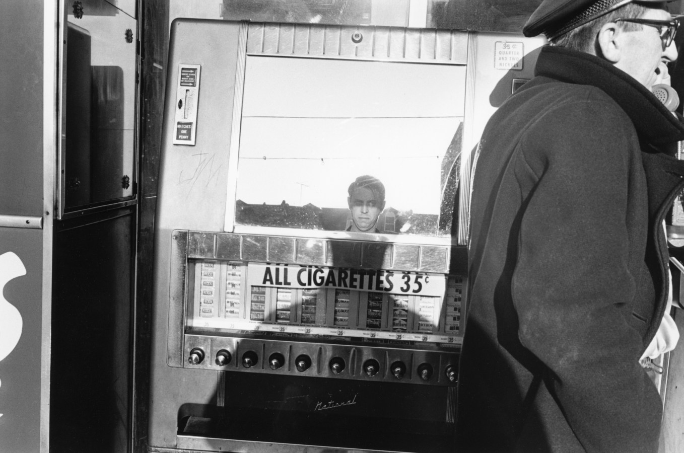 A black and white photograph of the artists reflection in a mirror.