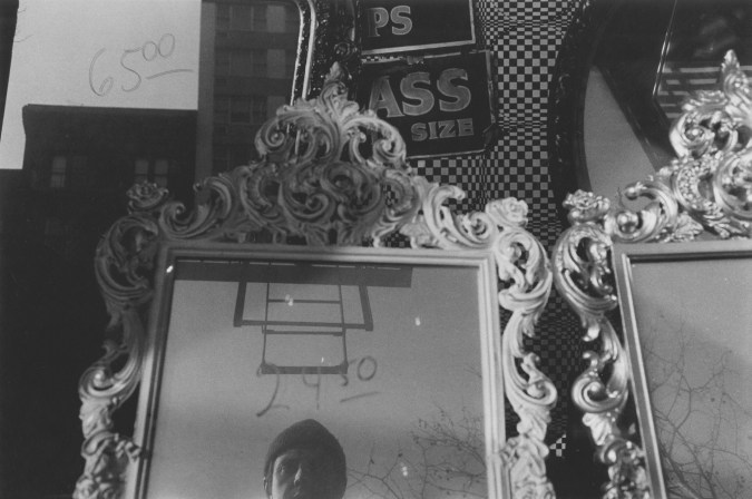 A black and white photograph of the artists reflection in a mirror.