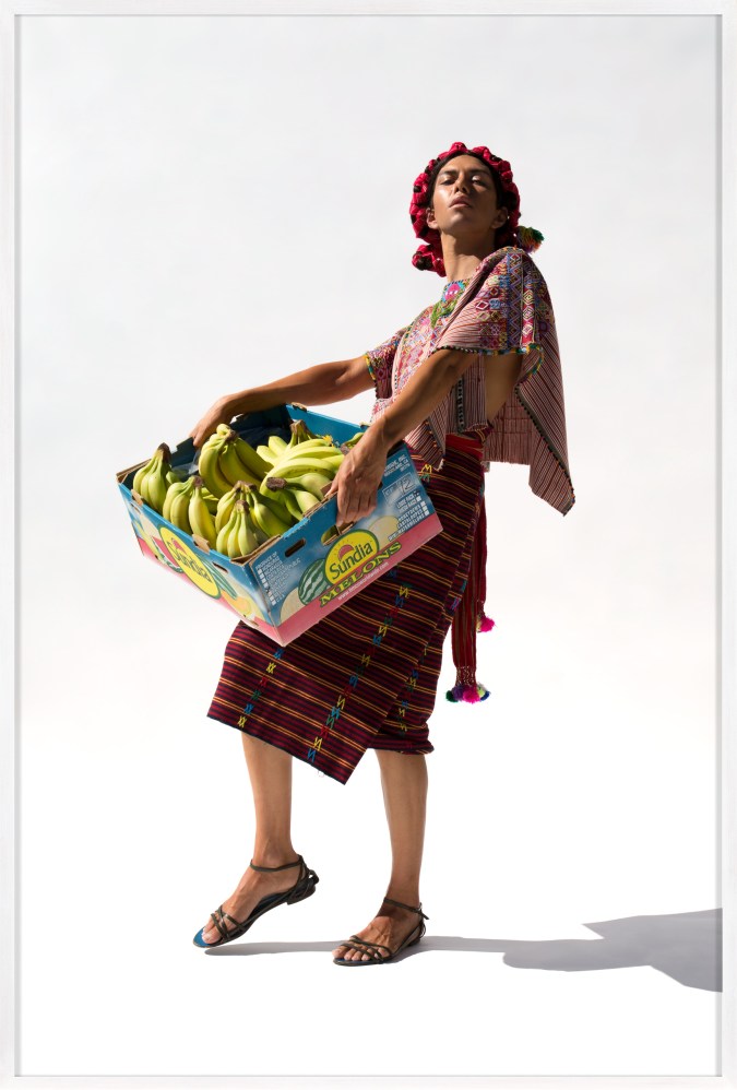 Framed color photograph of a woman holding a box of bananas