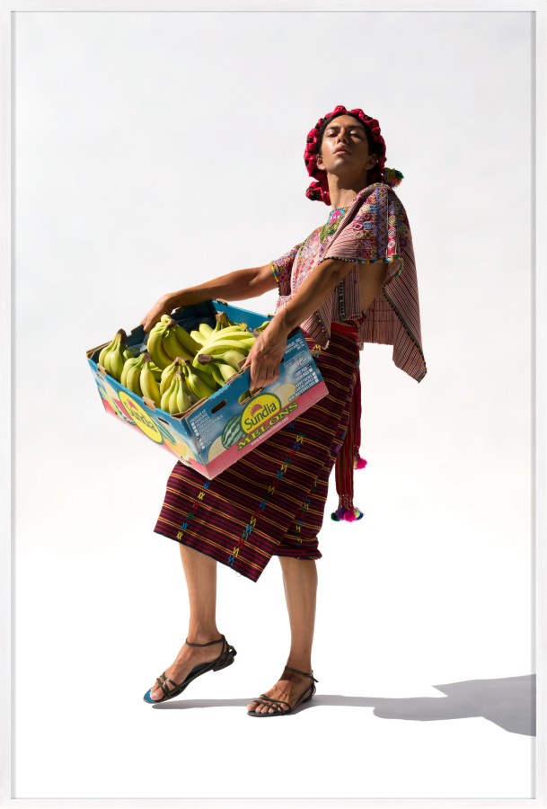Framed color photograph of a woman holding a box of bananas