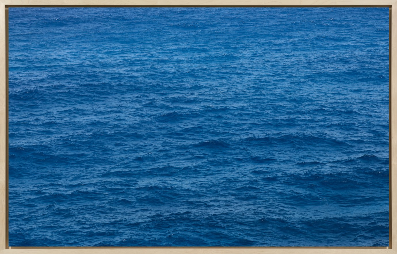 A framed image of a blue photograph depicting ocean waves