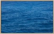 A framed image of a blue photograph depicting ocean waves