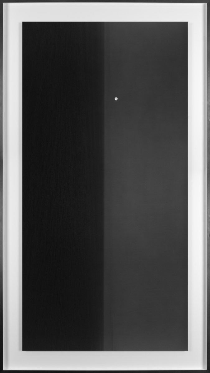 Black and white photograph of the ocean horizon with the moon slightly above the horizon line framed in black
