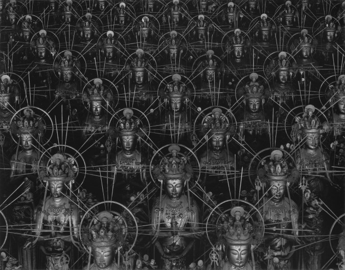 Black and white photograph of repeating statues of the Buddha