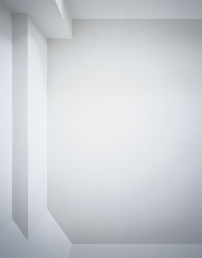Photograph of a white ceiling with simple linear architectural details in varying shades of light gray