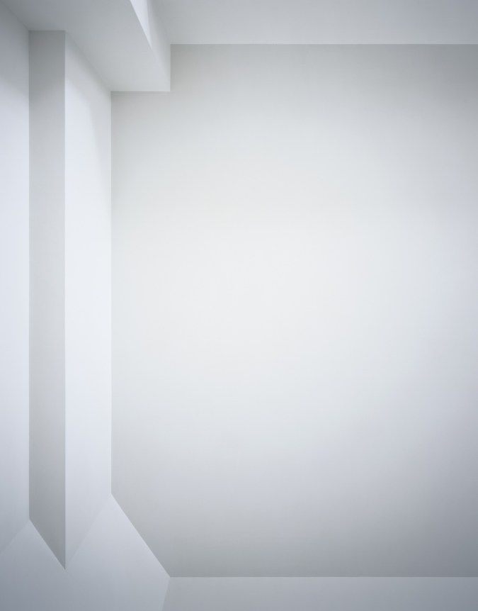 Photograph of a white ceiling with simple linear architectural details in varying shades of light gray